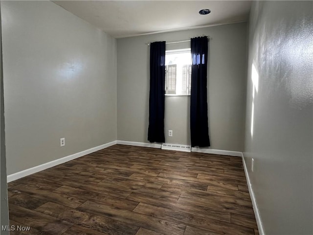 unfurnished room featuring dark wood-type flooring