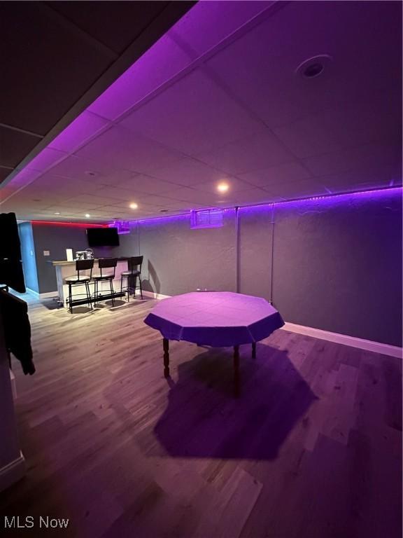 recreation room with hardwood / wood-style flooring and a paneled ceiling