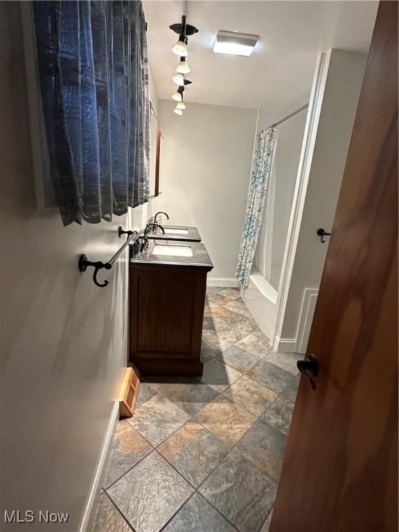 bathroom with vanity and shower / tub combo with curtain