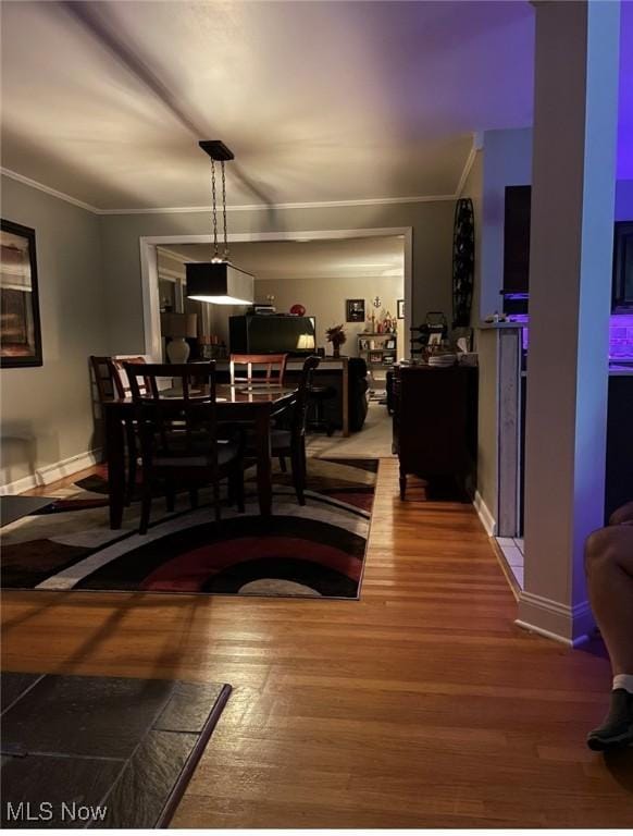 dining area with hardwood / wood-style flooring and ornamental molding