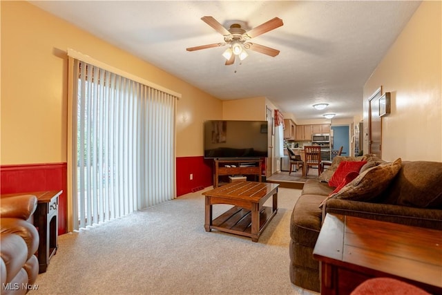 carpeted living room with ceiling fan