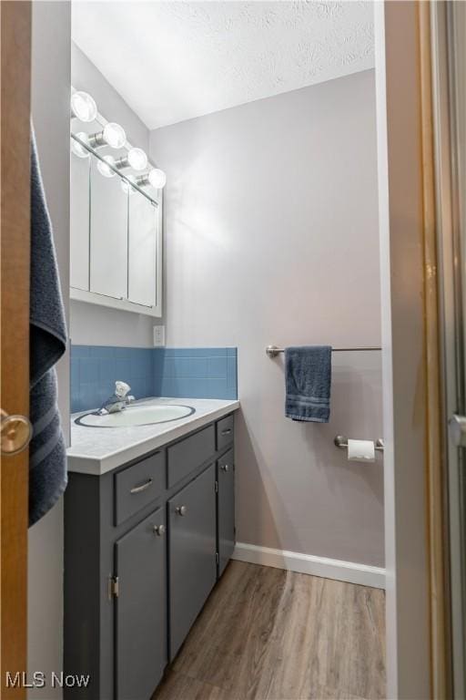 bathroom featuring vanity, hardwood / wood-style floors, and a textured ceiling