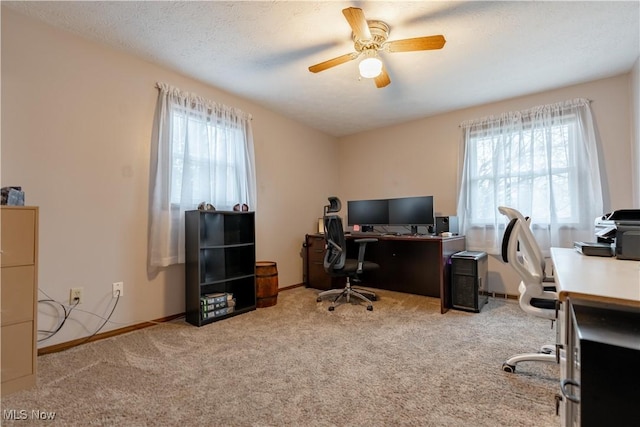 carpeted office with a healthy amount of sunlight, a textured ceiling, and ceiling fan