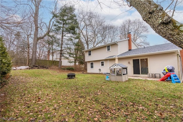 rear view of property with a gazebo, an outdoor fire pit, and a lawn