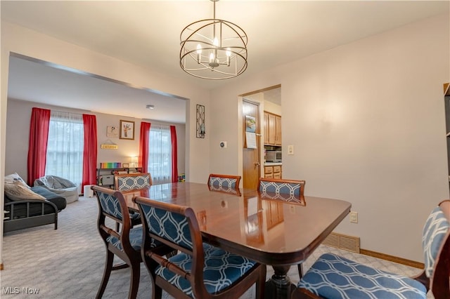 carpeted dining space featuring an inviting chandelier