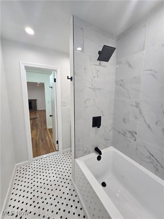 bathroom featuring tile patterned flooring and tiled shower / bath