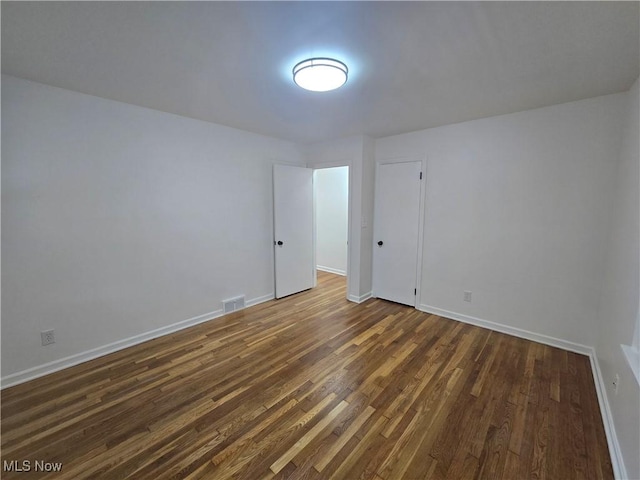 empty room with dark wood-type flooring