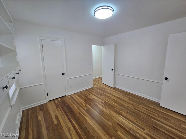 unfurnished room featuring dark hardwood / wood-style flooring