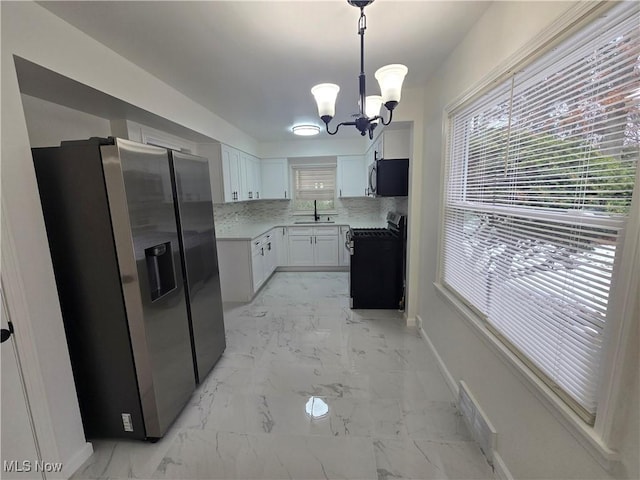 kitchen with white cabinetry, sink, gas stove, stainless steel refrigerator with ice dispenser, and a healthy amount of sunlight