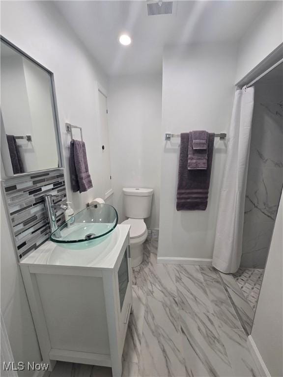 bathroom with vanity, curtained shower, backsplash, and toilet