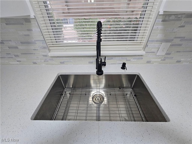 room details featuring sink and decorative backsplash