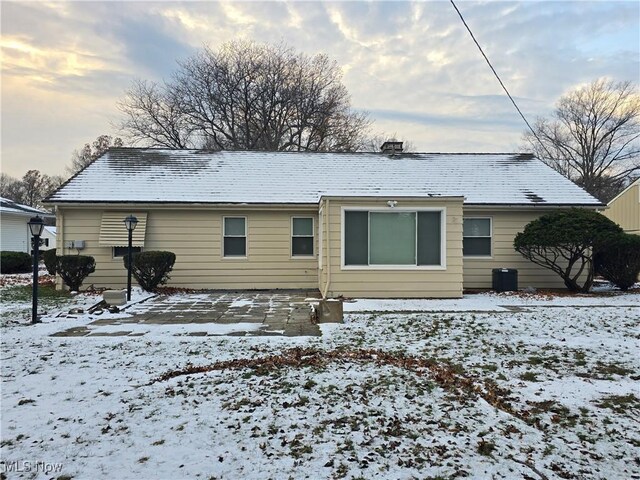 view of snow covered rear of property