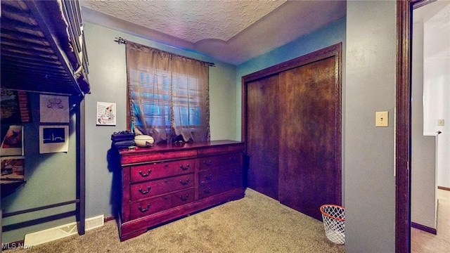 carpeted bedroom featuring a closet and a textured ceiling