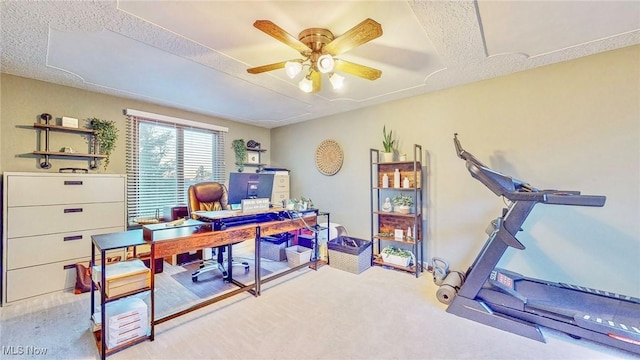 carpeted office space with a textured ceiling and ceiling fan