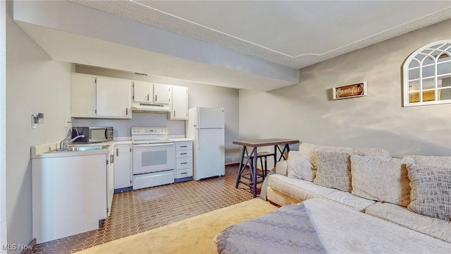 kitchen with white appliances, tile patterned floors, sink, and white cabinets