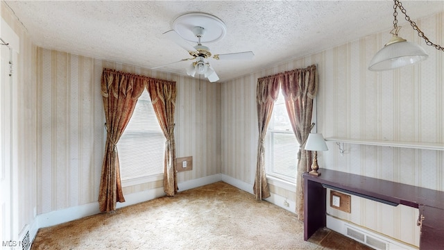 unfurnished room with ceiling fan, a textured ceiling, and carpet