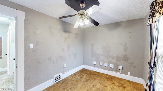 carpeted empty room with ceiling fan and a textured ceiling