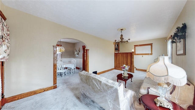 carpeted living room with a notable chandelier