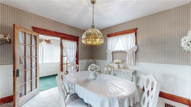 carpeted dining space with a notable chandelier