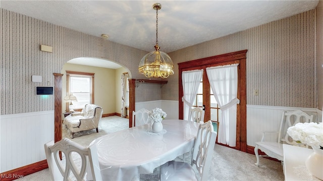 carpeted dining space with a chandelier