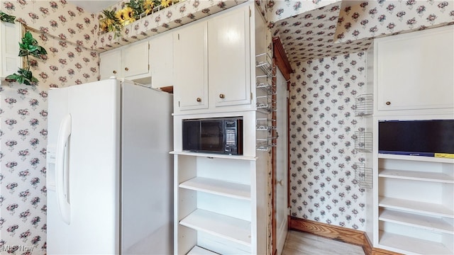 kitchen featuring white fridge with ice dispenser and white cabinets