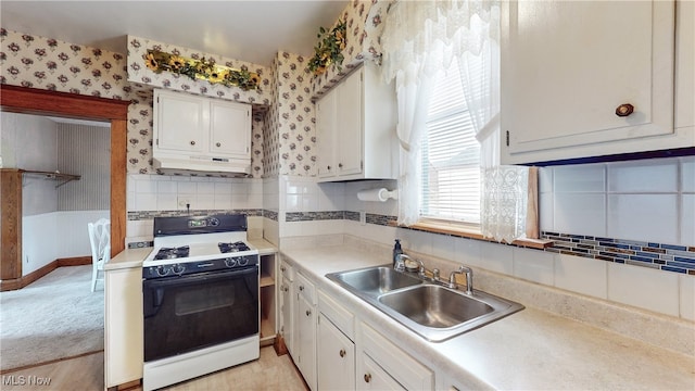 kitchen with sink, white cabinets, and gas range oven