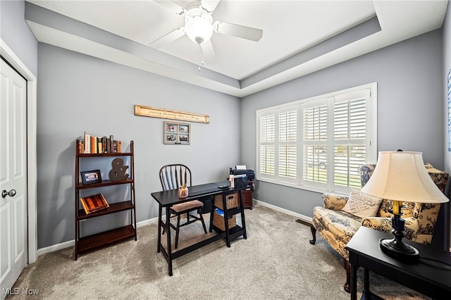 office with light carpet, ceiling fan, and a tray ceiling