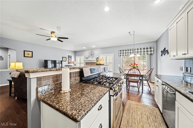 kitchen with stainless steel appliances, dark hardwood / wood-style floors, pendant lighting, and white cabinets