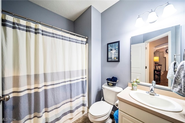 bathroom with vanity, walk in shower, a textured ceiling, and toilet