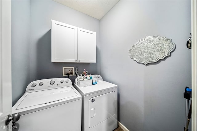 laundry area featuring cabinets, independent washer and dryer, and a textured ceiling