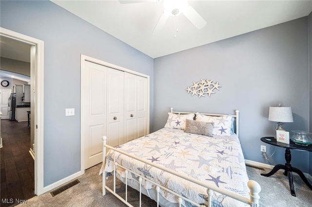 bedroom with stainless steel refrigerator, ceiling fan, and a closet