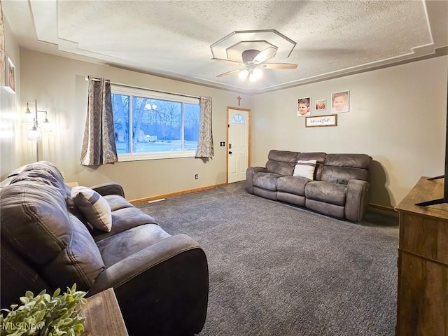 carpeted living room featuring ceiling fan and a textured ceiling