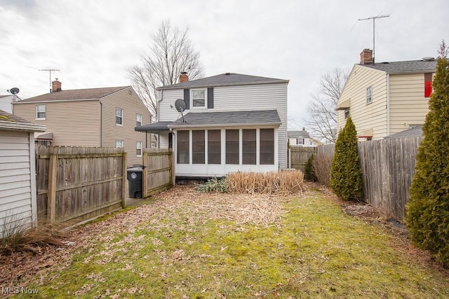 back of property featuring a lawn and a sunroom