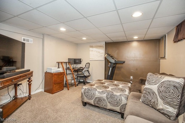 carpeted living room featuring a drop ceiling