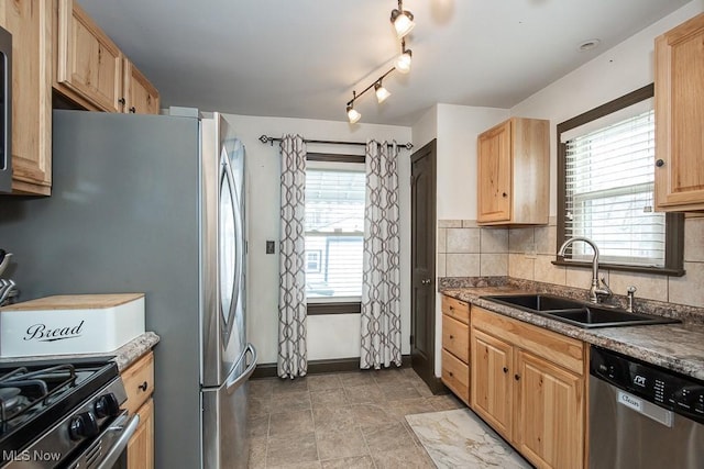 kitchen featuring stainless steel appliances, sink, light brown cabinets, and backsplash