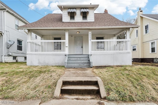 bungalow-style home with a front yard and covered porch