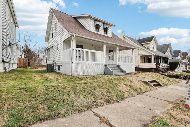 view of front of house featuring a porch, central AC unit, and a front yard