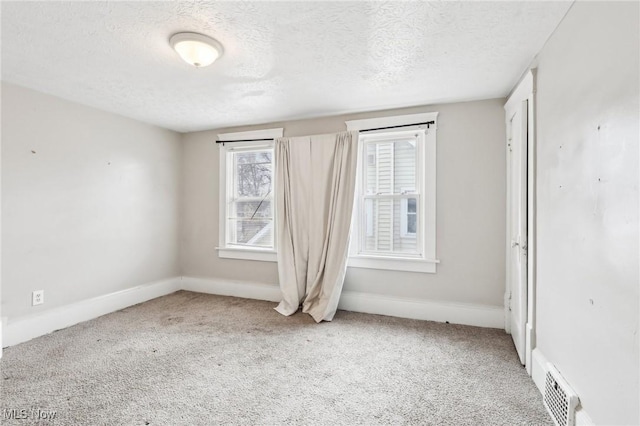 carpeted empty room with a textured ceiling