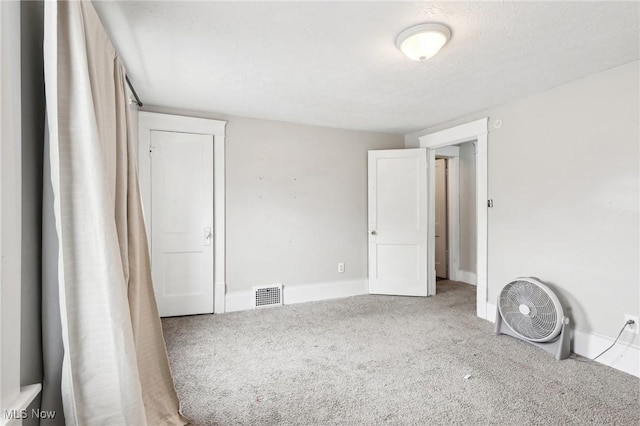 unfurnished bedroom featuring carpet and a textured ceiling