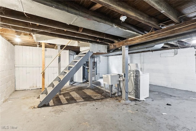 basement with washer / dryer, sink, and heating unit