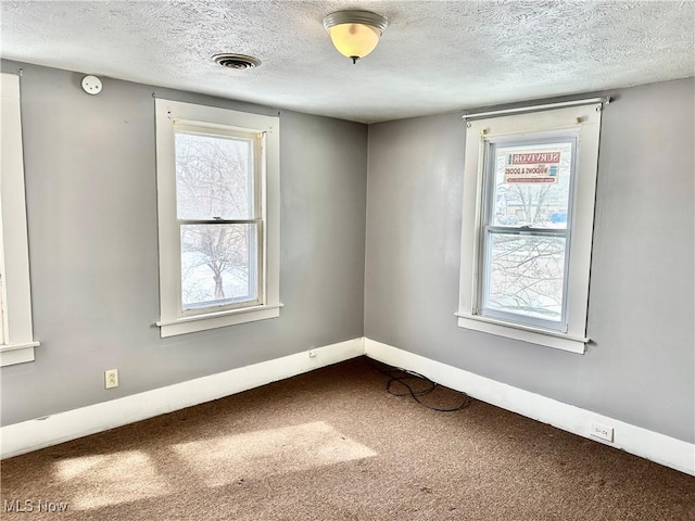 carpeted spare room featuring a textured ceiling