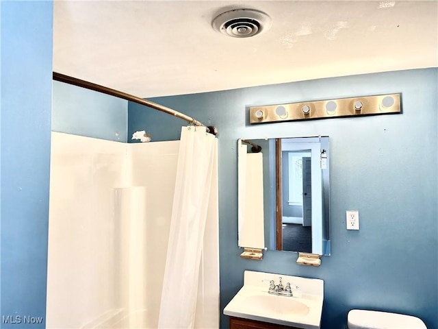 bathroom featuring vanity, a shower with shower curtain, and toilet