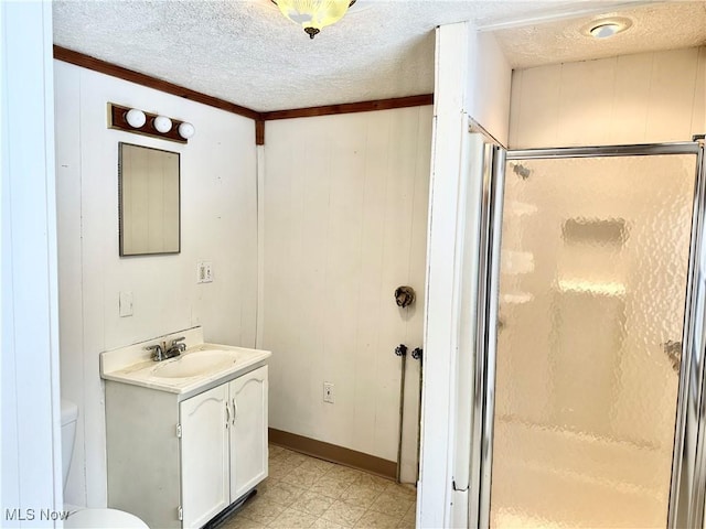 bathroom featuring vanity, toilet, a textured ceiling, and walk in shower