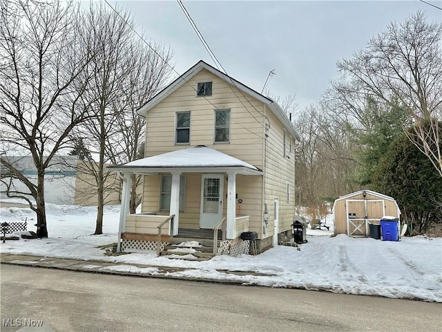 view of front of home with covered porch and a storage unit