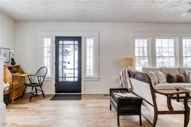 foyer with a textured ceiling and light wood-type flooring