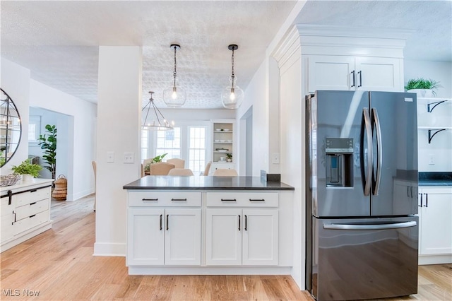 kitchen with pendant lighting, white cabinets, light hardwood / wood-style floors, and stainless steel fridge with ice dispenser