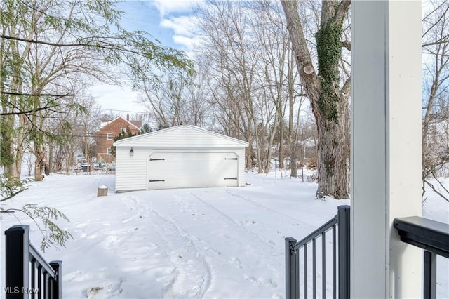 yard layered in snow with an outbuilding and a garage