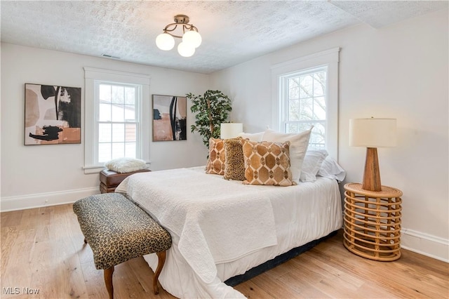 bedroom with hardwood / wood-style flooring and a textured ceiling