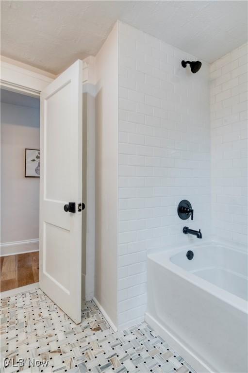 bathroom featuring tiled shower / bath