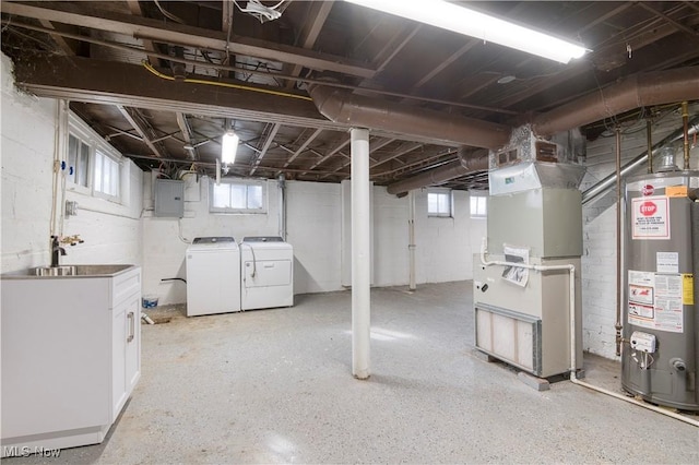 basement with heating unit, water heater, sink, washing machine and clothes dryer, and electric panel